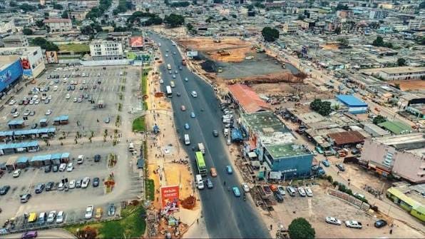 Vue aérienne d'un carrefour commerçant de Yopougon, boutiques et circulation dense