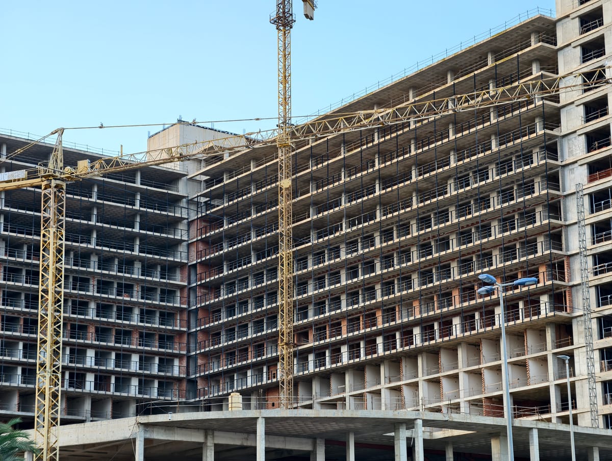 Immeubles de logements en construction avec grues, échafaudages et fenêtres vides