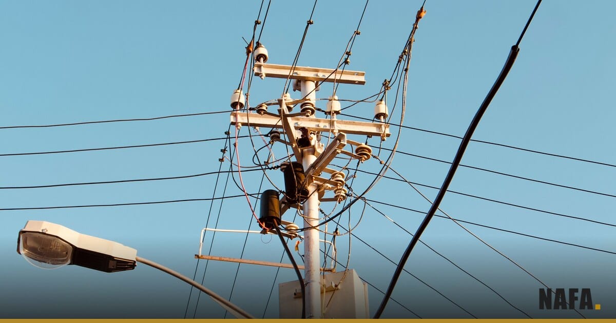 Poteau électrique et lignes à haute tension sous un ciel bleu