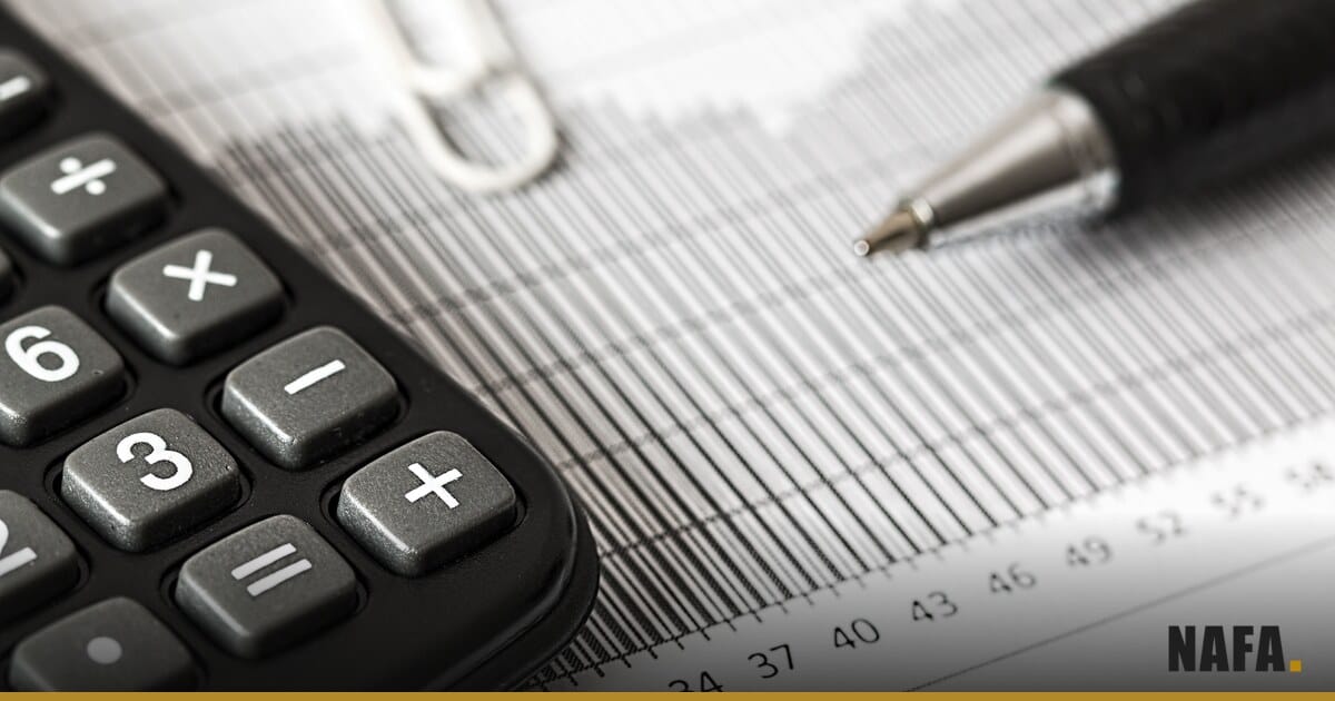 Calculatrice et stylo posés sur un graphique en barres