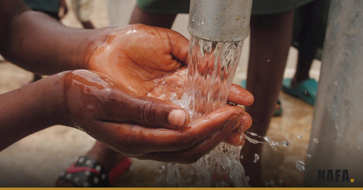 Des mains d'enfant recueillant de l'eau potable au robinet d'une pompe