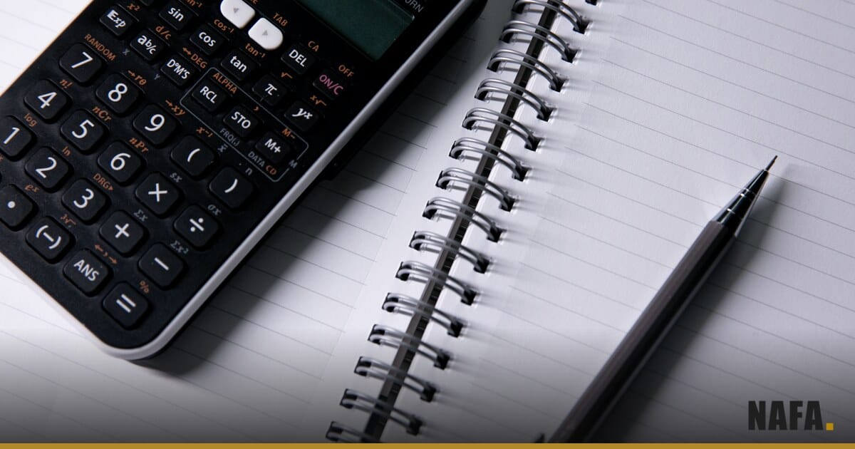 Documents, stylo et calculatrice sur un bureau pour vérifier un dossier de crédit.