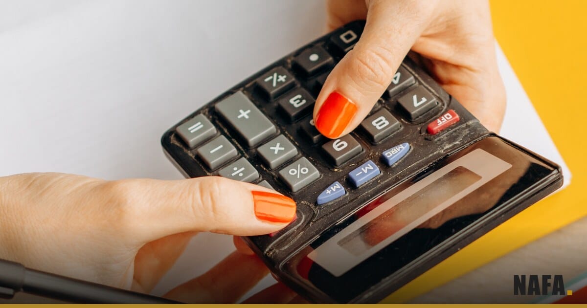 Mains utilisant une calculatrice sur un bureau.