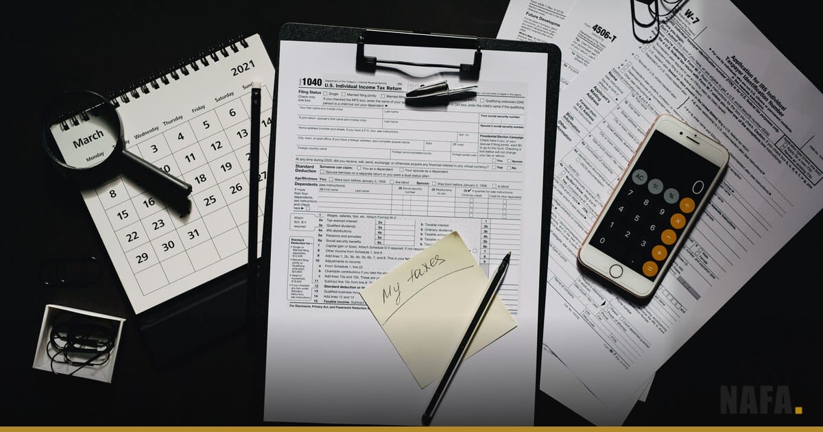 Calculatrice, formulaire fiscal, calendrier et stylo sur un bureau