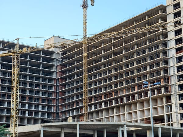 Immeubles de logements en construction avec grues, échafaudages et fenêtres vides