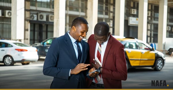 Deux hommes d'affaires en costume consultant un telephone dans une rue animee de Dakar