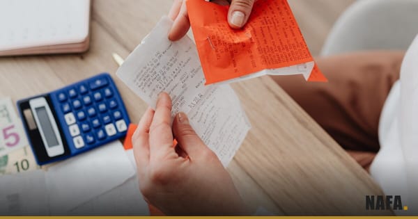 Mains comparant un devis papier à des informations sur un ordinateur.