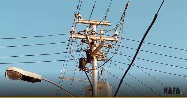 Poteau électrique et lignes à haute tension sous un ciel bleu