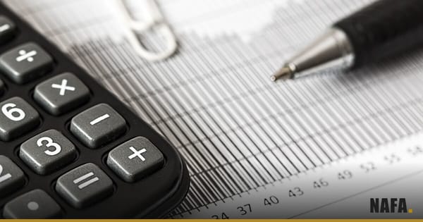 Calculatrice et stylo posés sur un graphique en barres