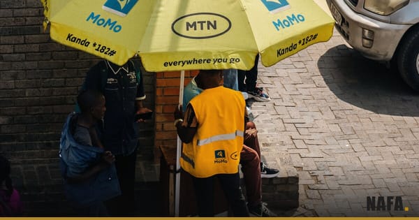 Vendeur de rue sous un parasol jaune MTN, scène de commerce de proximité en Afrique