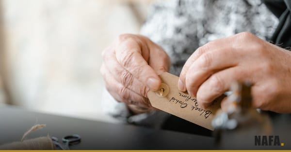 Des mains attachent une étiquette vierge sur un emballage avec de la ficelle.