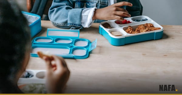 Enfants partageant un repas scolaire à table, visages non identifiables